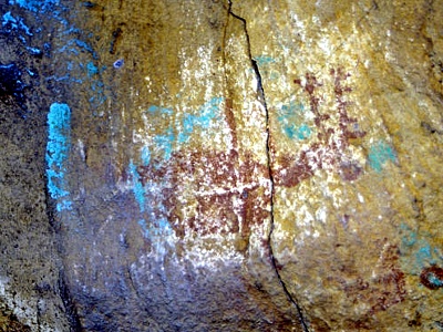 Arte rupestre dañado con pintura de color azul verdoso. 